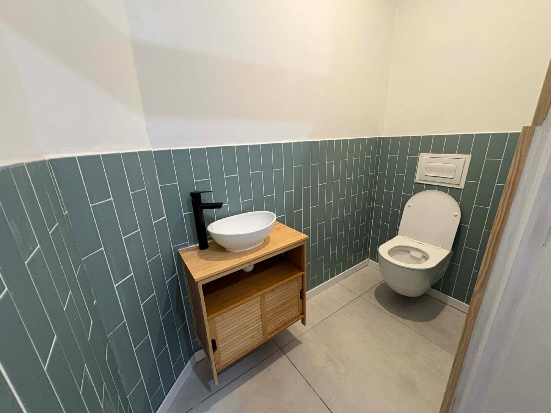 WC rénové avec carrelage vert et meuble vasque bois à Sérignan